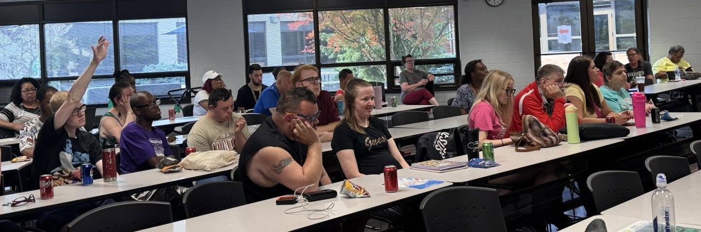 Individuals with DD seated at long tables in a conference room