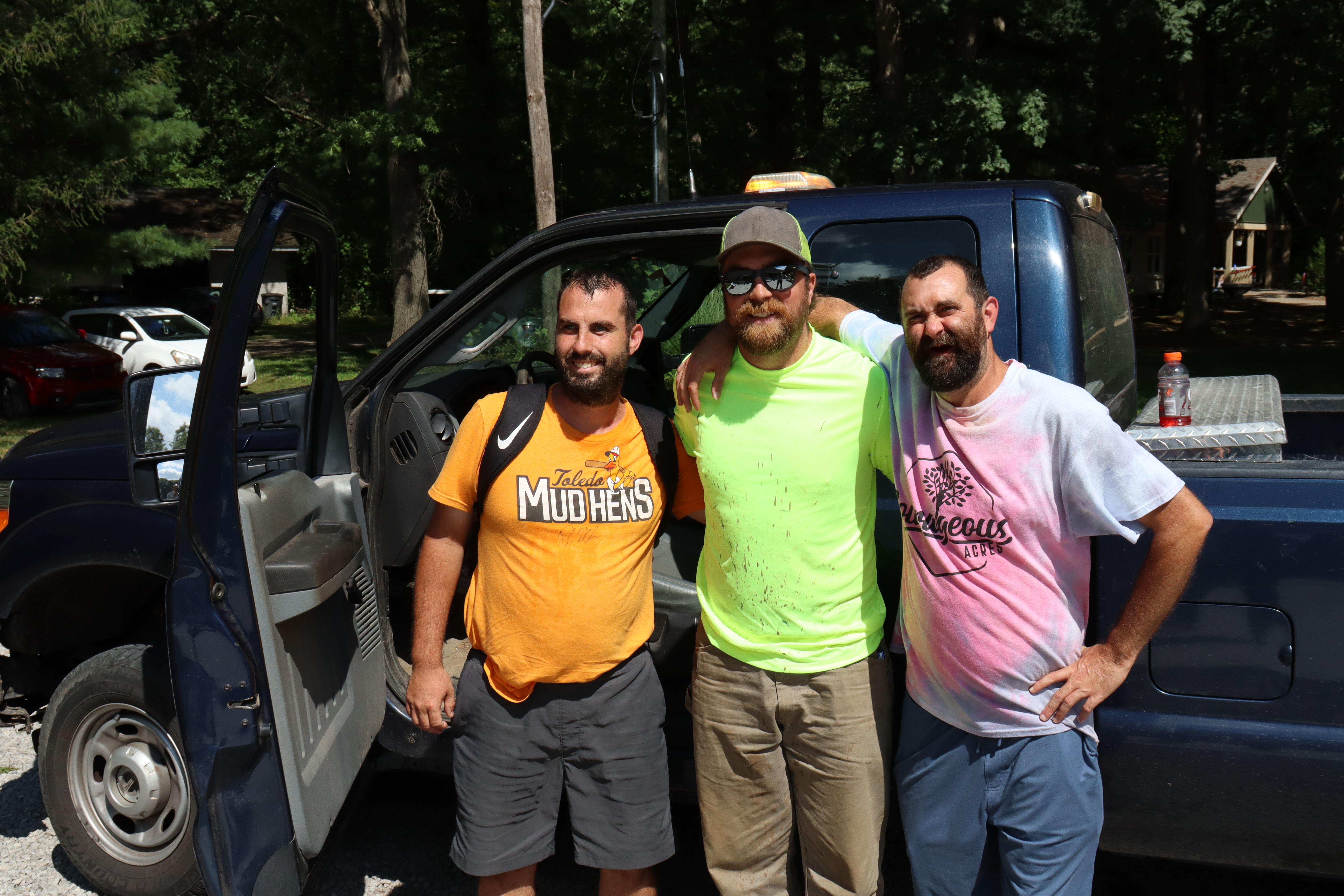 Jeremy, on the right, and another camper, on the left, pose with a Village of Whitehouse Public Works staffer in front of his truck.