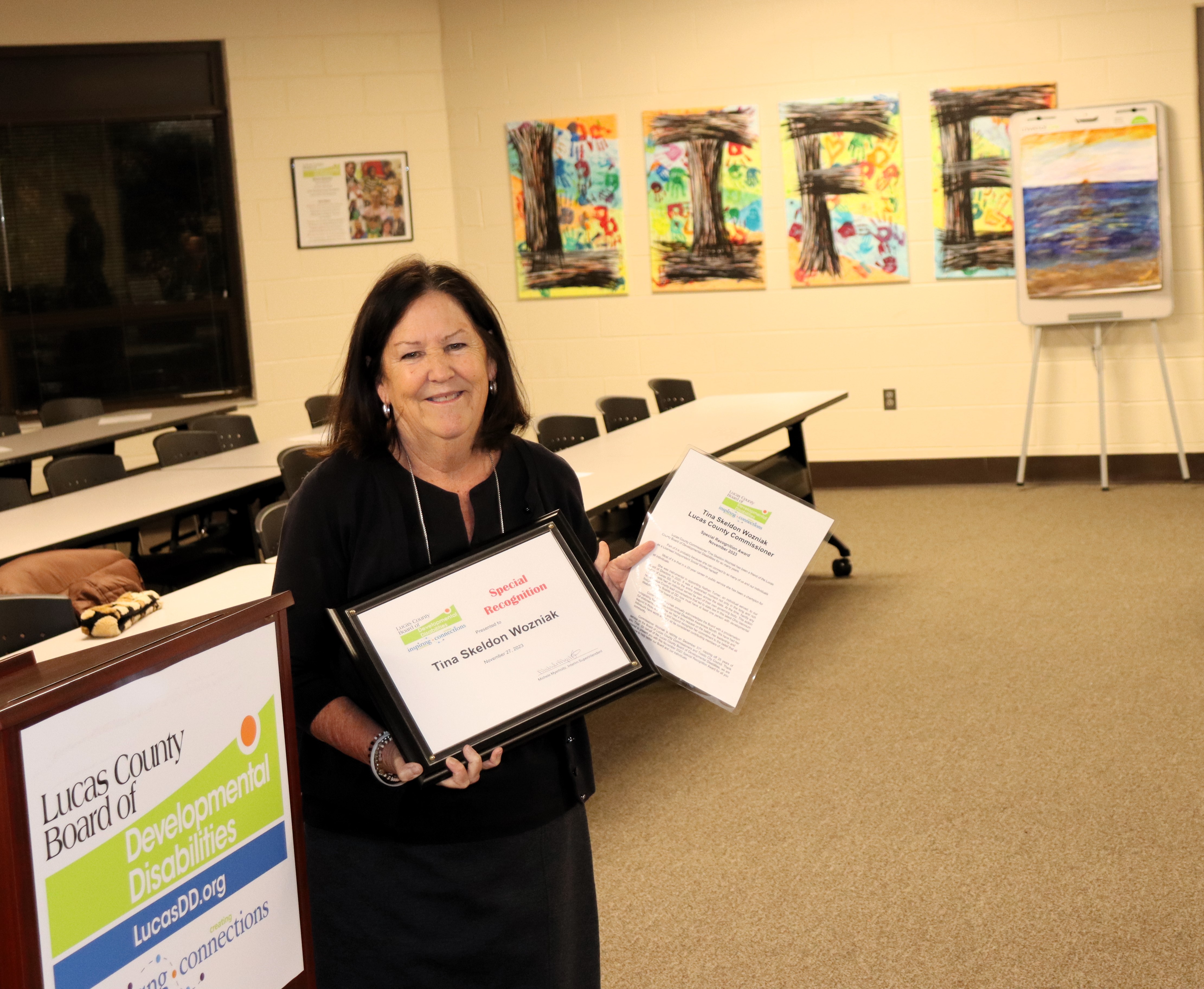 Commissioner Wozniak holds her award