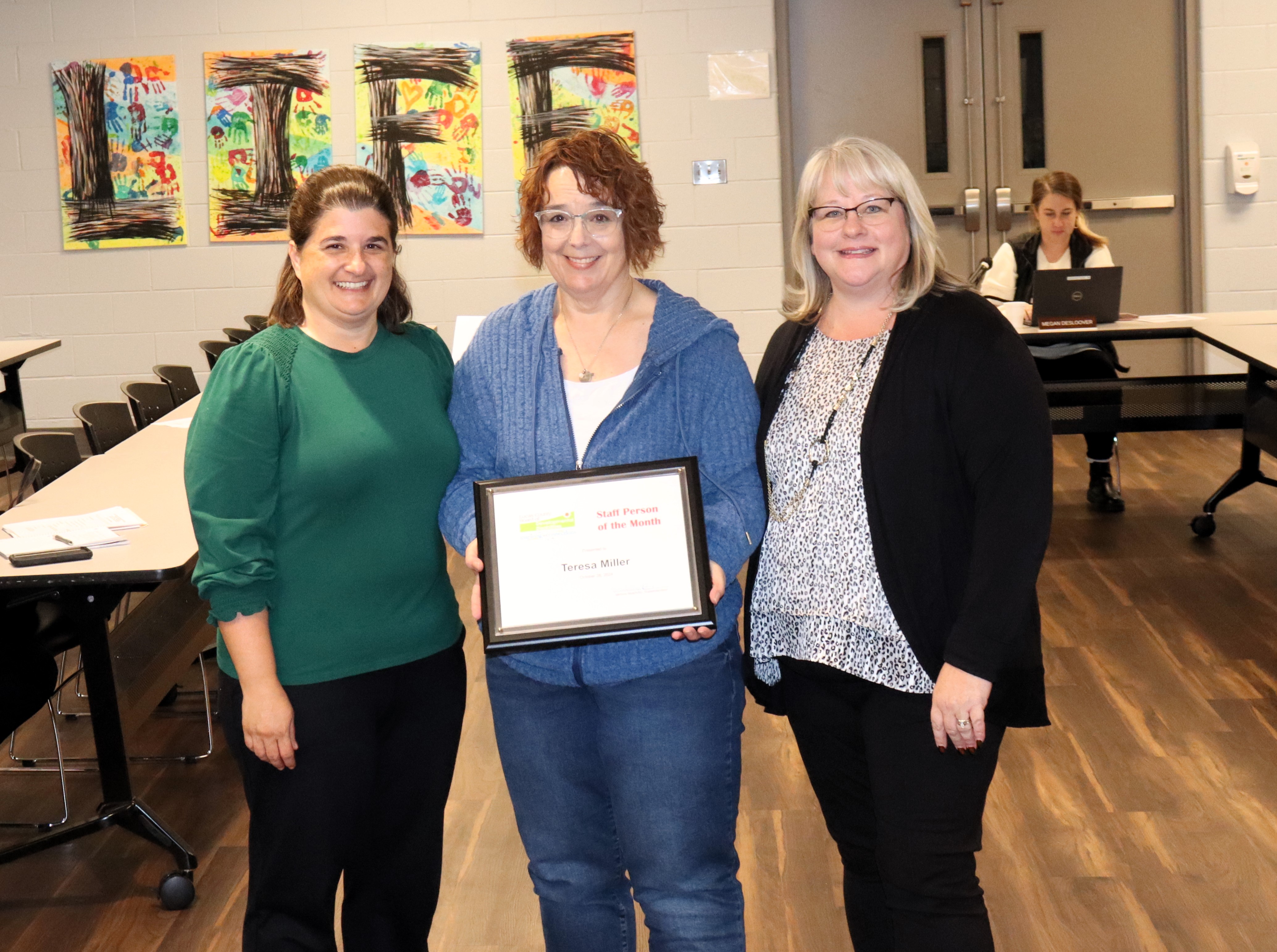 Lucas DD EIDS Teresa Miller holds her award. She is flanked by Records and Imaging Assistant Terri Fofrich and EI Coordinator Kristin Andrews