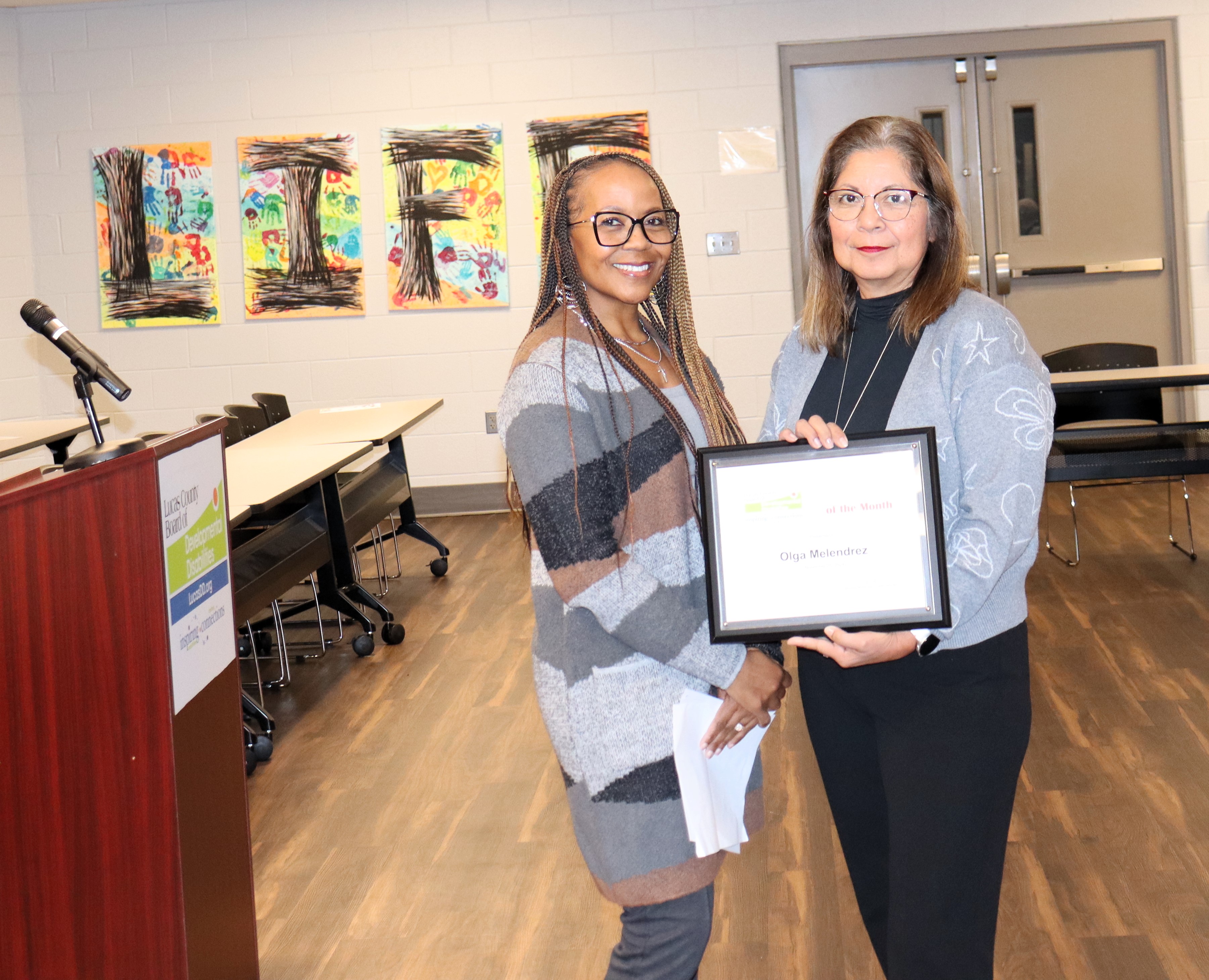 Lucas DD Data Analyst Olga Melendrez with her award plaque standing next to colleague Janine Dupree.