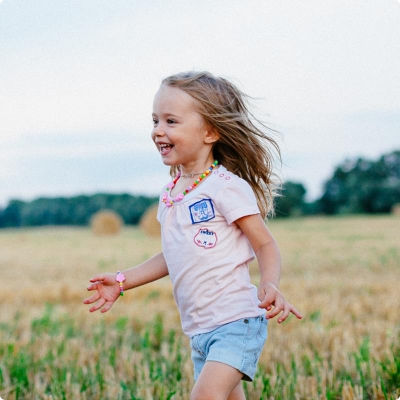 Little girl running in field