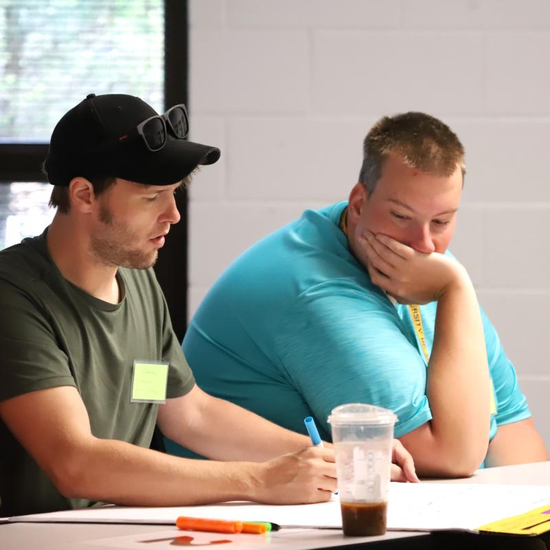 Two men looking at a paper together