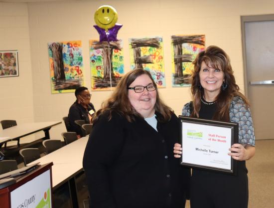 Photo of Michelle Turner holding her award next to Joclyn Brown